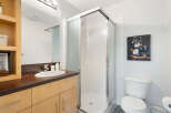 This modern bathroom features a sleek glass-enclosed shower and a stylish vanity with ample storage.