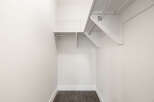This spacious closet offers ample storage with a sturdy metal hanging rod and a wire shelving unit above.