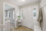 Step into a welcoming foyer featuring a bright white door with glass accents, flanked by sidelights.