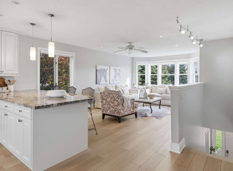 Experience seamless living in this open-concept home, featuring a modern kitchen with a granite-topped island and elegant pendant lighting.