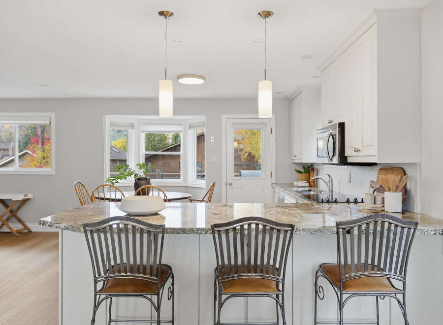 This spacious kitchen boasts a large granite island with comfortable seating, perfect for casual dining and entertaining.