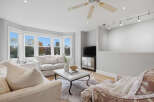 Step into this inviting living room, bathed in natural light from the large bay windows offering scenic views.