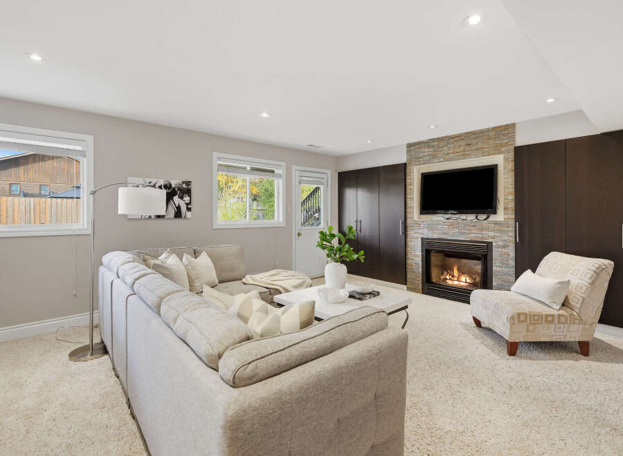 Cozy up by the fireplace in this inviting living room, featuring a plush sectional sofa and a stylish accent chair.