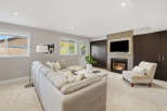 Cozy up by the fireplace in this inviting living room, featuring a plush sectional sofa and a stylish accent chair.