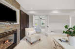 Experience cozy evenings by the fireplace, featuring a stacked stone surround and a mounted television.