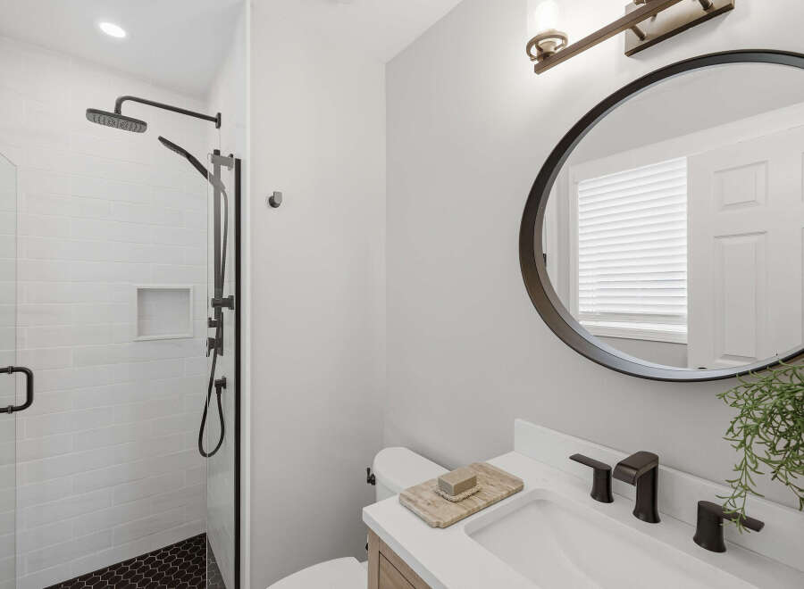 Experience modern comfort in this beautifully appointed bathroom, featuring a sleek walk-in shower with subway tile and a built-in niche.