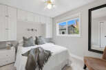 This cozy bedroom features a comfortable queen-size bed adorned with plush decorative pillows and a soft throw blanket.