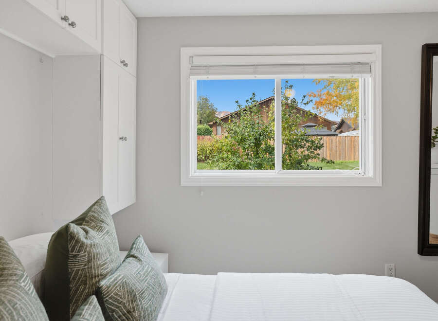 This bedroom offers ample storage with built-in white cabinets, perfect for organizing your belongings.