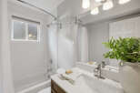 This bright and airy bathroom features a classic white subway tile shower and tub surround, complemented by a sleek chrome showerhead and faucet.