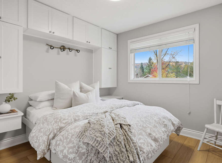 Experience cozy living in this charming bedroom, featuring a comfortable bed adorned with plush pillows and a stylish duvet.