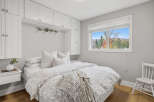 Experience cozy living in this charming bedroom, featuring a comfortable bed adorned with plush pillows and a stylish duvet.