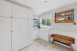 This spacious room features ample storage with floor-to-ceiling white cabinets and additional built-in cabinetry.