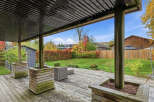 Enjoy outdoor living under this covered patio, complete with a spacious wooden deck perfect for entertaining.