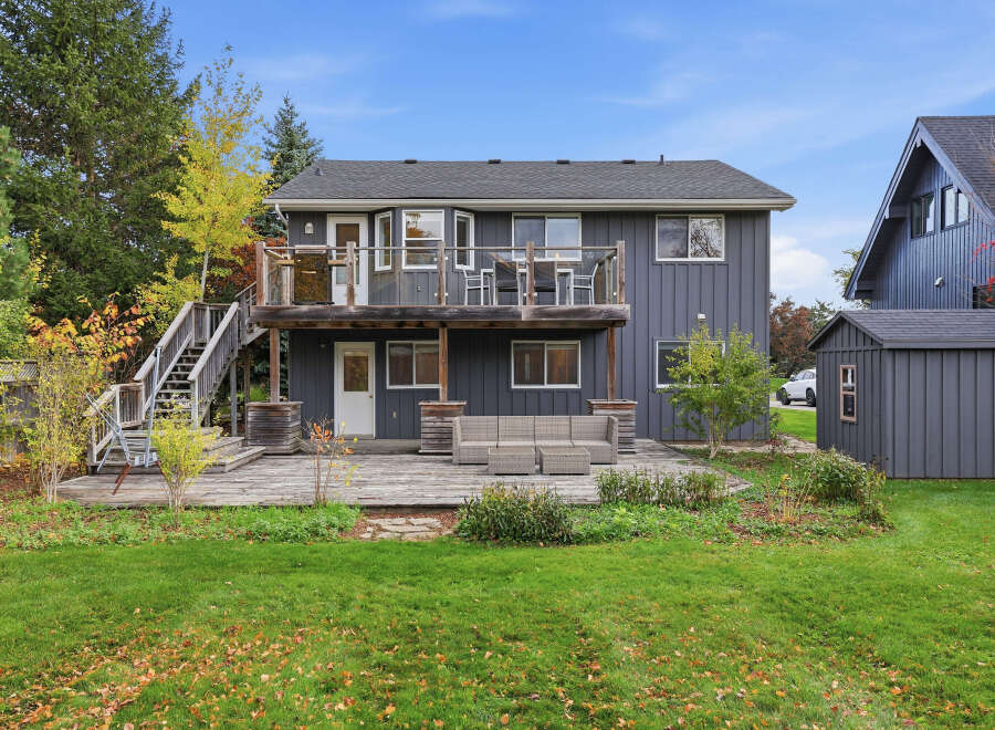Enjoy outdoor living with this spacious backyard featuring a multi-level deck and a lower patio area perfect for entertaining.