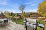 Enjoy outdoor living on this spacious deck, complete with a dining set and a Weber grill, perfect for entertaining.