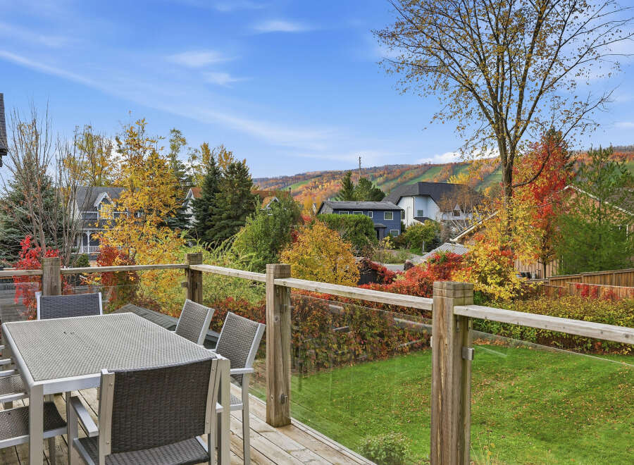 Enjoy breathtaking autumn views from this spacious deck, complete with a modern dining set perfect for al fresco meals.