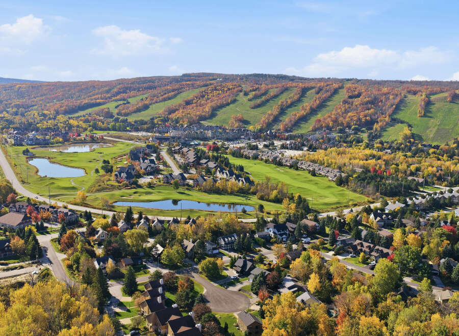 Experience the beauty of autumn in this stunning aerial view of a golf course community.