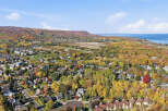 Experience the vibrant beauty of autumn from this stunning aerial view of a residential neighborhood nestled amidst colorful fall foliage.
