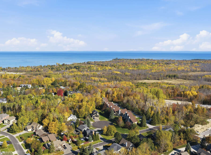 Experience the beauty of autumn from this aerial view of a residential neighborhood nestled amongst vibrant fall foliage.
