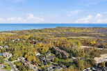 Experience the beauty of autumn from this aerial view of a residential neighborhood nestled amongst vibrant fall foliage.