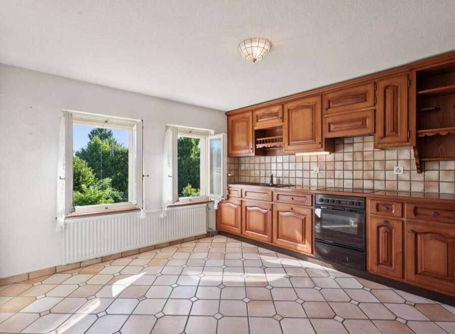 This charming kitchen features warm, honey-toned wooden cabinetry offering ample storage and a classic aesthetic.