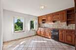 This charming kitchen features warm, honey-toned wooden cabinetry offering ample storage and a classic aesthetic.