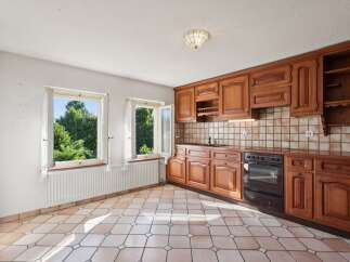 This charming kitchen features warm, honey-toned wooden cabinetry offering ample storage and a classic aesthetic.