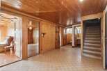 Step into a charming, wood-paneled interior featuring a grand grandfather clock and a cozy seating area.
