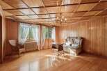 Step into a warm and inviting living space, featuring rich wood paneling and a coffered wood ceiling that exudes rustic charm.
