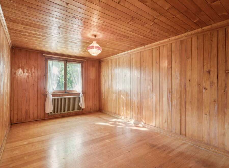 Step into this charming room featuring warm, natural wood paneling on both the walls and ceiling, creating a cozy and inviting atmosphere.