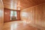 Step into this charming room featuring warm, natural wood paneling on both the walls and ceiling, creating a cozy and inviting atmosphere.