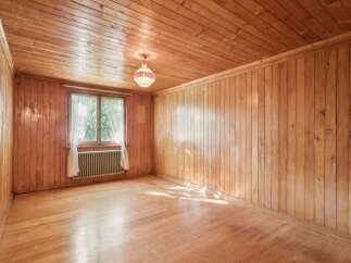 Step into this charming room featuring warm, natural wood paneling on both the walls and ceiling, creating a cozy and inviting atmosphere.