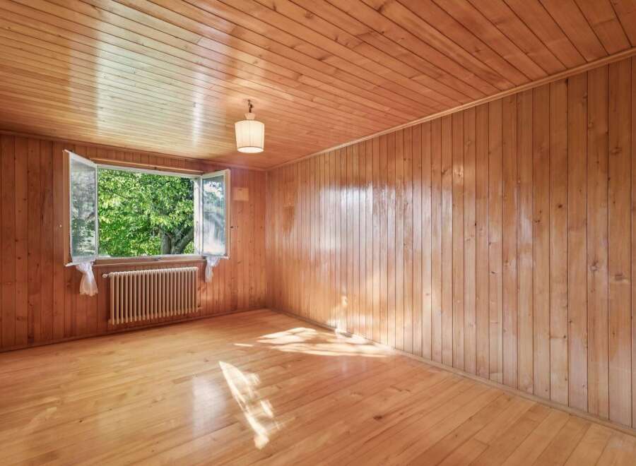 Step into this charming room featuring warm, natural wood paneling on the walls and ceiling, creating a cozy and inviting atmosphere.