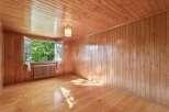 Step into this charming room featuring warm, natural wood paneling on the walls and ceiling, creating a cozy and inviting atmosphere.