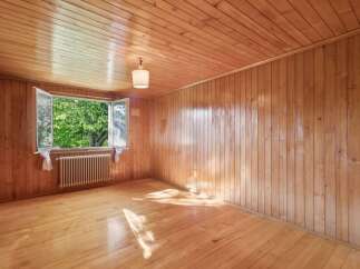 Step into this charming room featuring warm, natural wood paneling on the walls and ceiling, creating a cozy and inviting atmosphere.