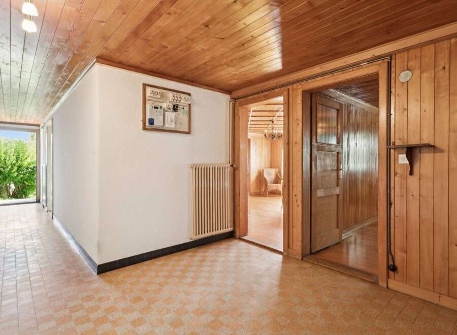 Step into a charming entryway featuring warm wooden ceilings and paneling, creating a cozy and inviting atmosphere.