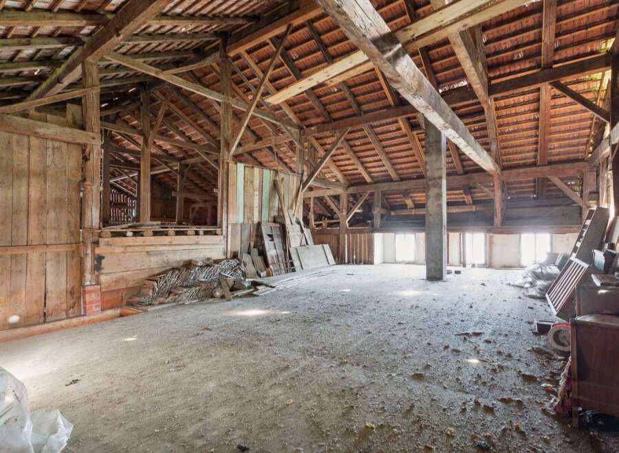 Explore the potential of this expansive barn, featuring a robust timber frame and a traditional tiled roof, offering a unique opportunity for renovation or conversion.