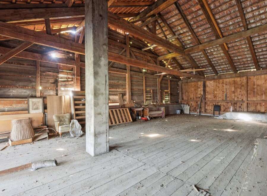 Step into this spacious barn, featuring a robust wooden beam structure and a tiled roof, offering ample room for storage or conversion.