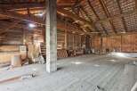Step into this spacious barn, featuring a robust wooden beam structure and a tiled roof, offering ample room for storage or conversion.