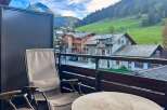 Enjoy breathtaking mountain views from this charming balcony, complete with comfortable seating and a table, perfect for morning coffee or evening relaxation.
