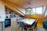 Experience cozy dining in this charming room featuring a rustic wooden ceiling and exposed beams.