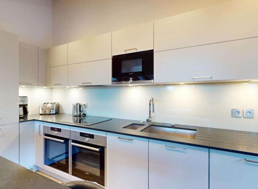 Experience modern living in this sleek kitchen, featuring high-end stainless steel appliances including a built-in microwave and double ovens.