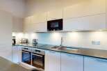 Experience modern living in this sleek kitchen, featuring high-end stainless steel appliances including a built-in microwave and double ovens.