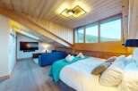 Experience luxury mountain living in this beautifully appointed bedroom featuring a comfortable king-size bed, plush white linens, and a vibrant teal throw blanket.