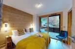 Experience cozy mountain living in this charming bedroom featuring two comfortable beds adorned with warm yellow blankets and decorative pillows.
