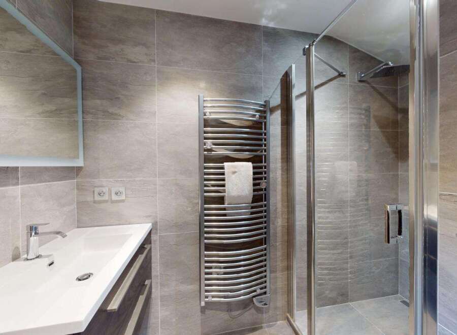 Experience modern luxury in this beautifully appointed bathroom, featuring a sleek vanity with a vessel sink and a spacious walk-in shower with a rainfall showerhead.
