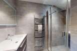 Experience modern luxury in this beautifully appointed bathroom, featuring a sleek vanity with a vessel sink and a spacious walk-in shower with a rainfall showerhead.