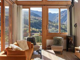 Experience breathtaking mountain views from this stunning living room, featuring a cozy fireplace and ample natural light.