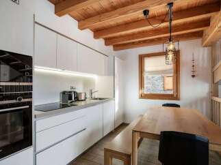 This modern kitchen features sleek white cabinetry and integrated Siemens appliances, including a built-in oven and stovetop.