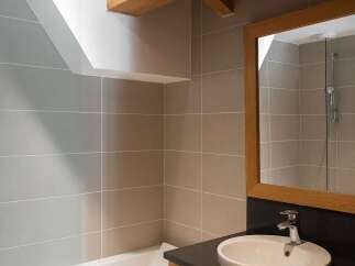 Experience rustic charm in this bathroom, featuring a deep soaking tub and a modern vanity with an oval sink.